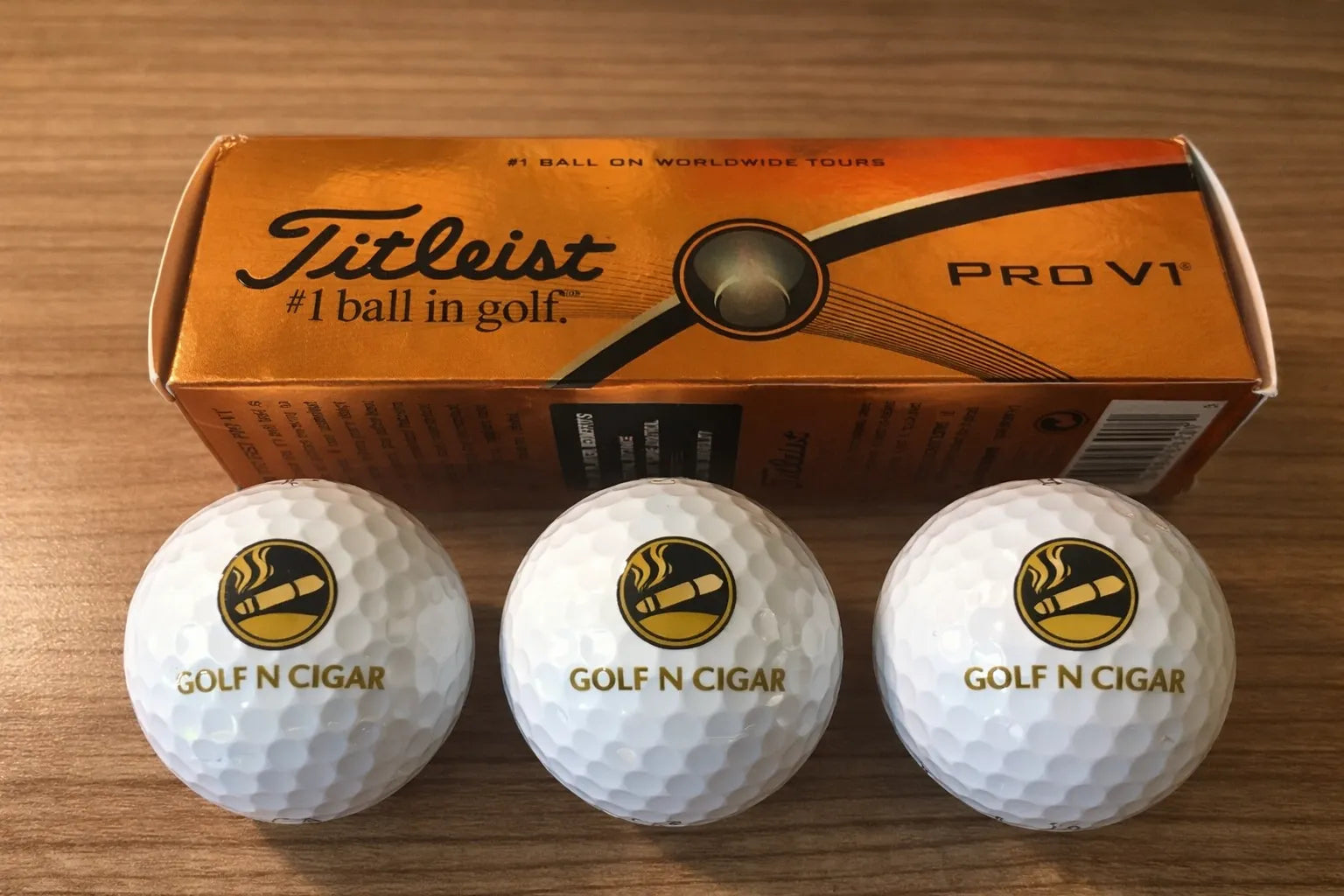 Three Titleist Pro V1 golf balls with Golf N Cigar gold logo and orange box